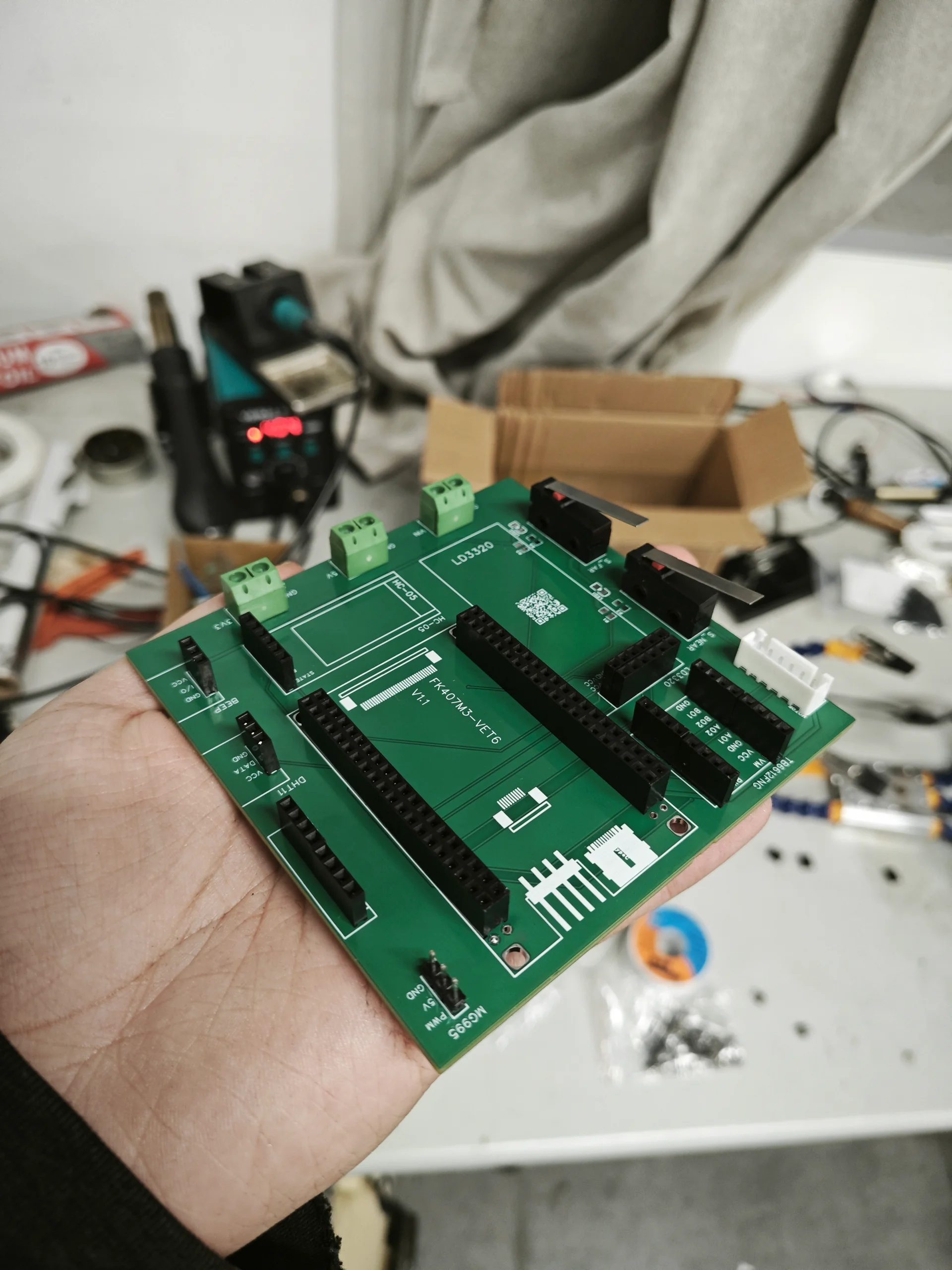 手持绿色电路板背景工作台