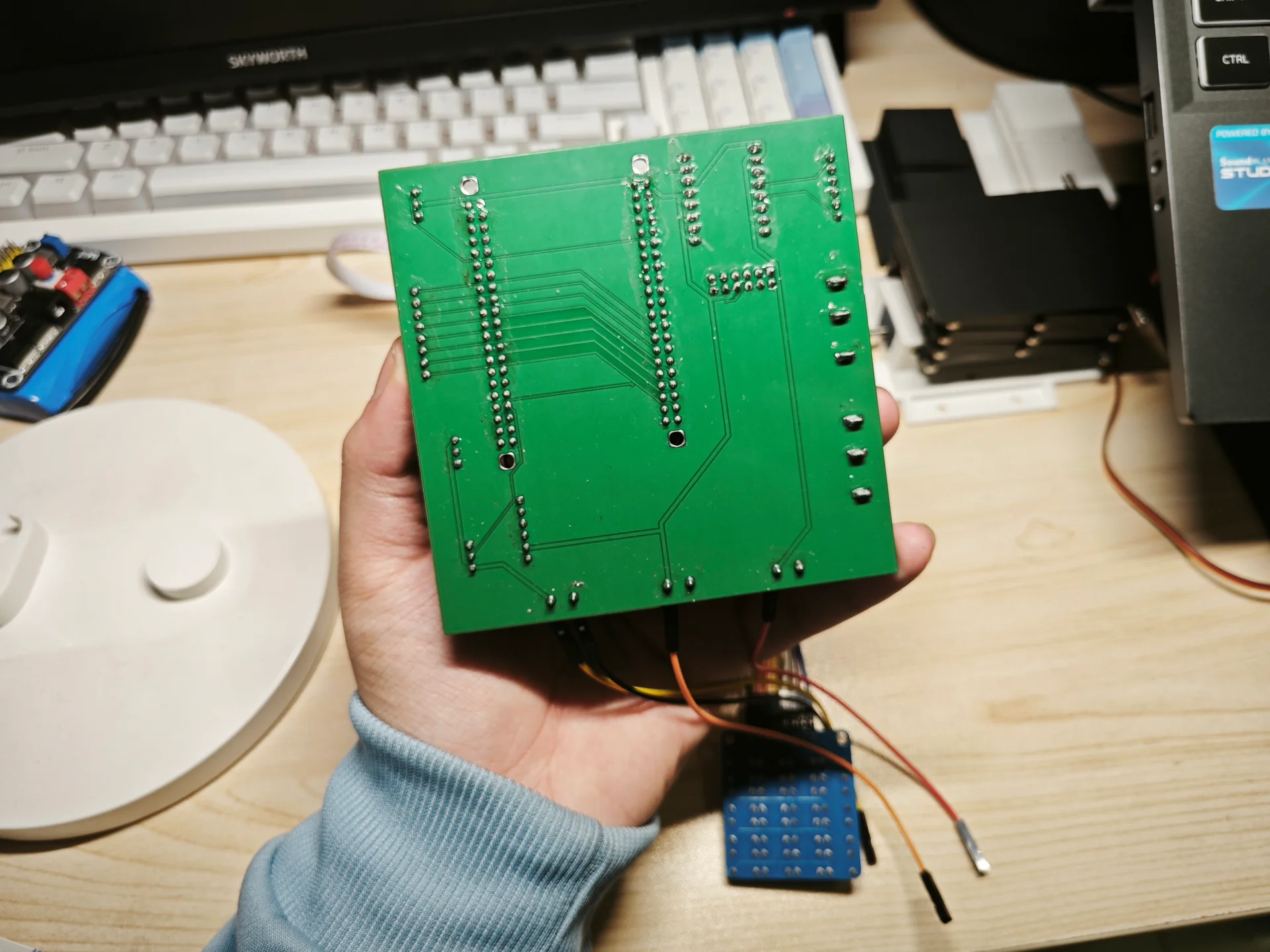 手持绿色电路板连接蓝色模块